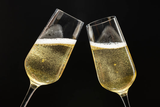 Zwei Gläser alkoholfreier Sekt stoßen feierlich an – prickelnd, festlich und elegant.